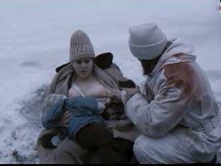 Голодный солдат пьет молоко с груди толстой женщины